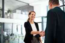Shot of a businesswoman and businessman shaking hands in a modern office
